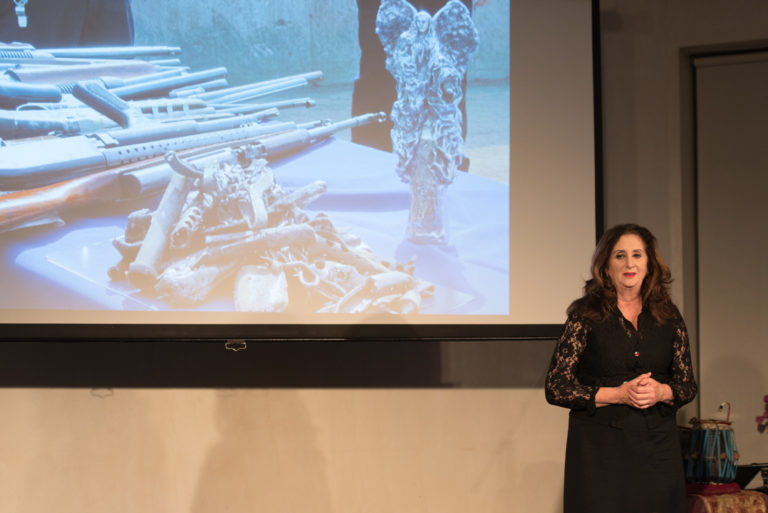 Lin Evola showing guns melted into Peace Angel sculptures (TEDxFultonStreet photo by Eriq Ortiz) 2016-09-21